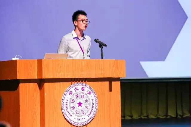 一名年轻发言者站在清华大学校徽讲台后致开幕辞。