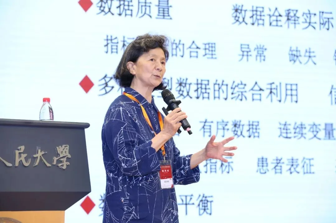 一名演讲者手持麦克风站在讲台旁，身后投影着中文要点。