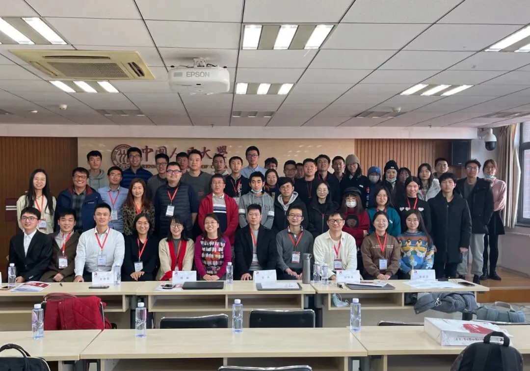 数十名参会者和会务人员在教室讲台前分排合影。