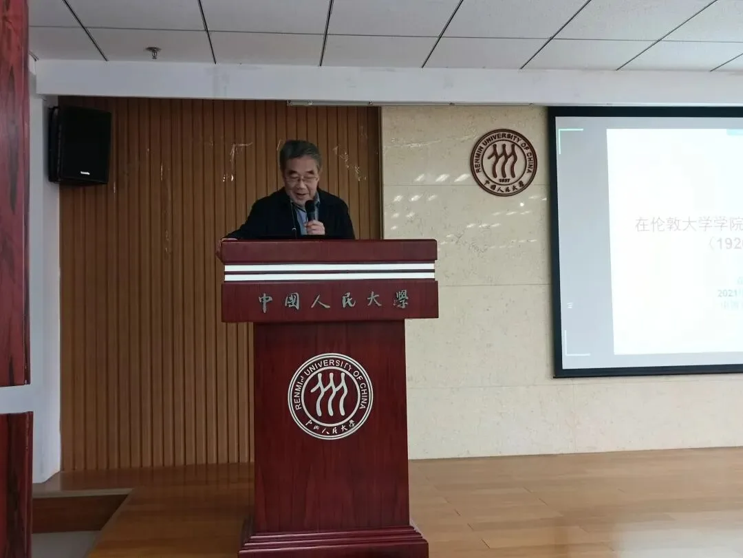 一名演讲者站在中国人民大学讲台后发言，右侧屏幕显示报告内容。
