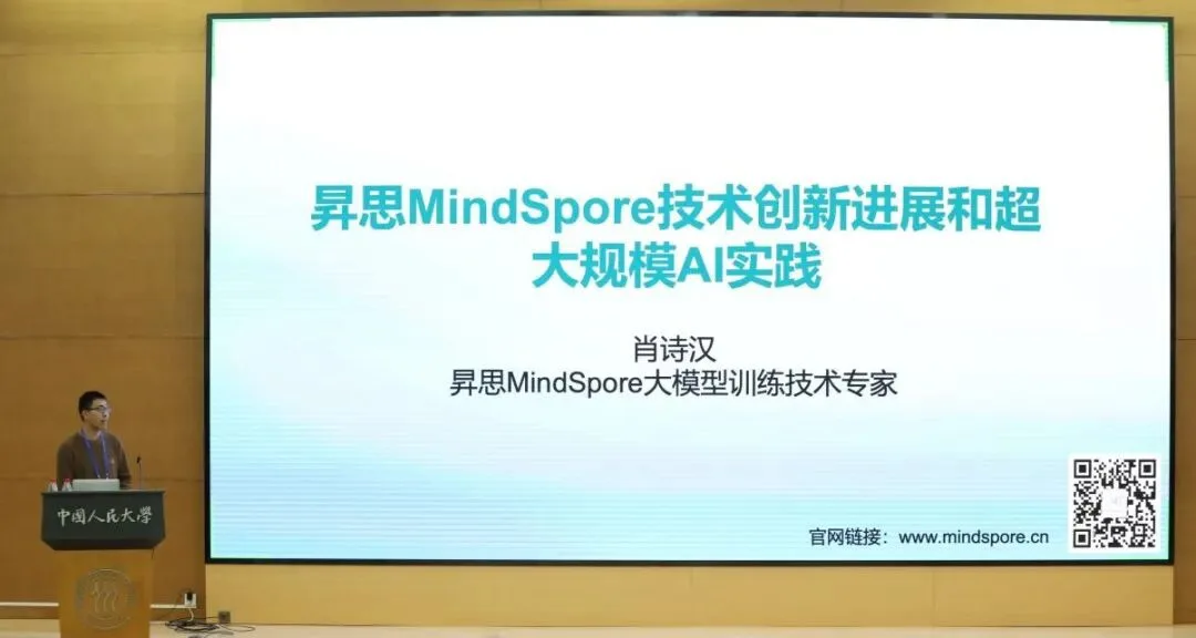 一名嘉宾在讲台上演讲，身后大屏幕显示MindSpore技术主题报告标题。